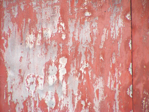 Old rusty metal texture. Peeling painted red surface. Grunge background with damaged paint. © chaiko
