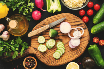 Fototapeta na wymiar Cutting vegetables for healthy salad. Top view cooking process, vegan or vegetarian salad preparation