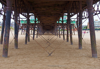 view underneath the pier showing metal supports and structure on the beach in lytham saint annes in lancashire