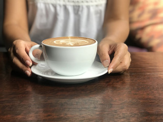 Hot cappuccino white coffee cup with latte art on wooden table background in cafe. Food and drink concept.	