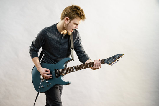 Young man playing electric guitar
