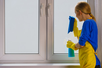 Woman cleaning window at home