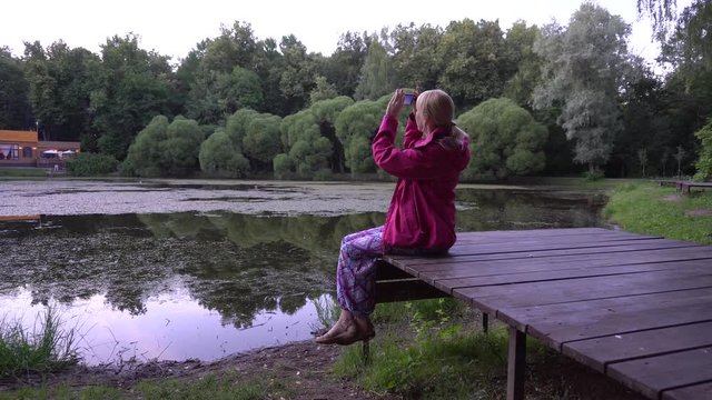 Young woman taking pictures of the sky 4k