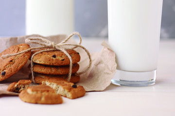 cookies with milk breakfast concept with glass and bottle of milk on light background and wooden table
