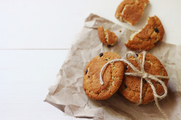 oat cookies with chocolate top view on light wooden background. craft paper and bow on cookie