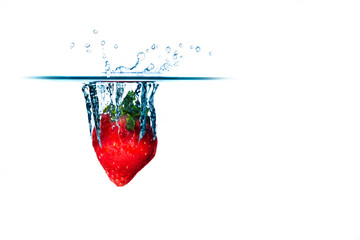 A fresh and delicious red strawberry isolated on a white background. Red strawberry dropping in water and creating a splash. The concept of healthy eating, consuming fruit.