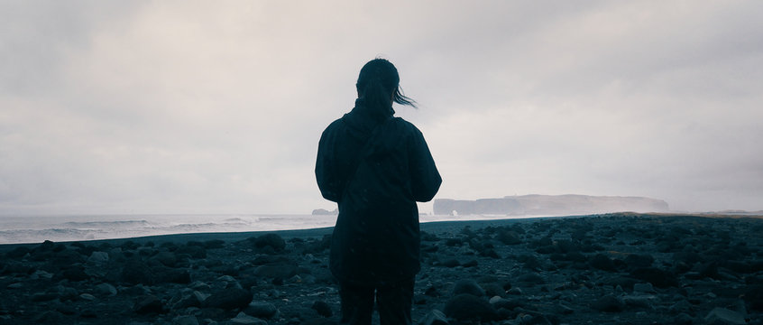 Woman overlooking the horizon at Reynisfjara, Icleand.
