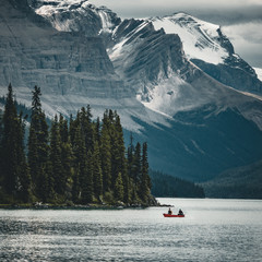 a canoe on maligne lake in summer with a backdrop of the canadian rockies in jasper national park, alberta, canada