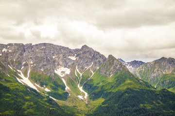 Fototapeta premium View from the top of the San Gottardo Pass to the mountain valley against the background of passing clouds