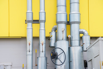 metal pipes with manometers and valves on  the yellow wall