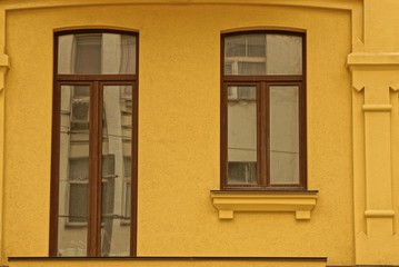 Fototapeta na wymiar two modern windows on the brown wall of the house