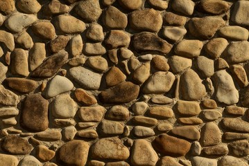 gray brown stone texture of cobblestones in the wall