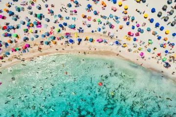 Luftaufnahme des Sandstrandes mit bunten Sonnenschirmen, schwimmende Menschen in der Meeresbucht mit transparentem blauem Wasser am sonnigen Morgen im Sommer. Reisen Sie auf Mallorca, Balearen, Spanien. Ansicht von oben. Landschaft © den-belitsky