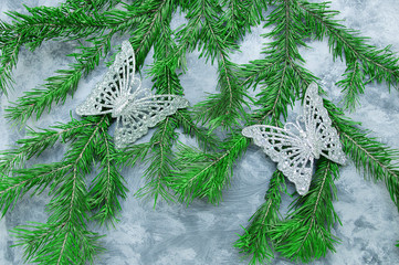 Christmas decorations of a butterfly on a Christmas tree. On a concrete background.