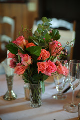 Wedding Reception Table Decorated with Silver and a Pink, White, and Green Centerpiece of Roses