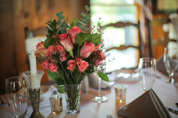 Wedding Reception Table Decorated with Silver and a Pink, White, and Green Centerpiece of Roses