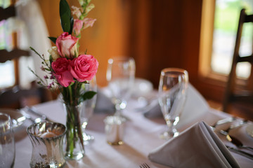 Wedding Reception Table Decorated with Silver and a Pink, White, and Green Centerpiece of Roses