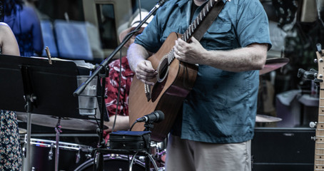 A closeup of band member playing guitar in small city venue in Downtown Cleveland, Ohio