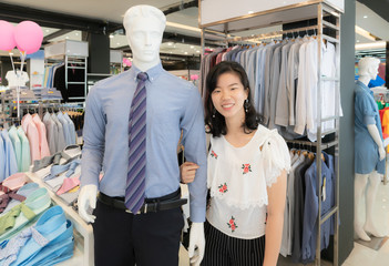 Shopping and couple concept : Smile Asian woman in casual fashion, walk arm in arm together with a mannequin in shirt with necktie.