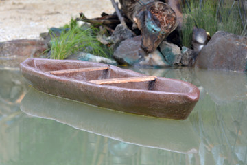 Carved wooden canoe on a body of water - Powered by Adobe