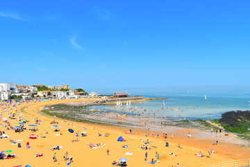 Tourists on their summer holidays. Viking beach in the coastal town of Broadstairs, Kent county gets really busy during the summer school holidays. Broadstairs, Kent, UK - obrazy, fototapety, plakaty