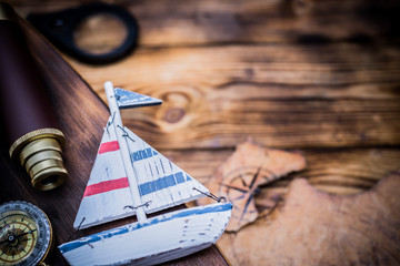 Columbus Day. Vintage worldmap and discovery equipment. Copy space on dark wood background.