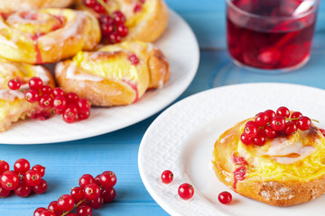 Pudding Schnecken Kuchen mit Johannisbeeren Obst auf Holz Hintergrund türkis