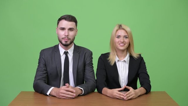 Young business couple as newscasters together