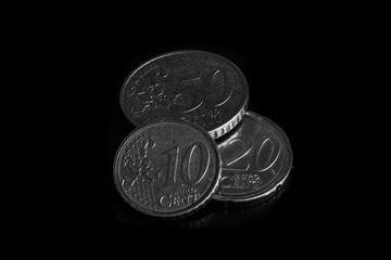 Coins on black background in black and white