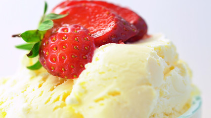 Summertime vanilla ice cream macro closeup with strawberry fruit.