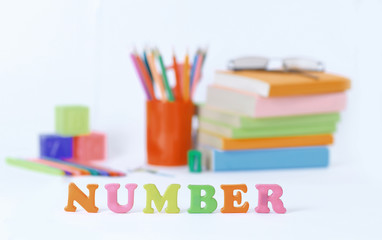 Fototapeta premium word number on blurred background of school supplies .photo with copy space