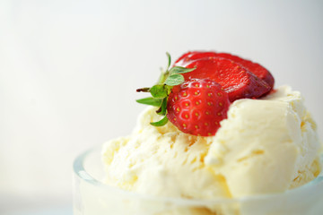 Summertime vanilla ice cream macro closeup with strawberry fruit.