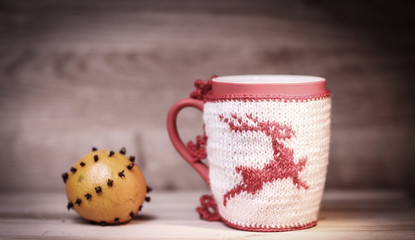 decorative Christmas Cup and orange on wooden background.