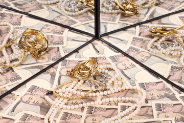 Fototapeta na wymiar 鏡に映る一万円札と宝飾品 