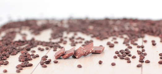black coffee beans and chocolates on wooden background