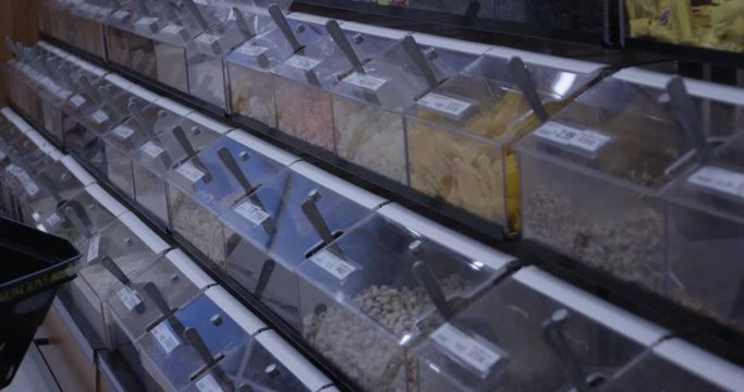 shopper looking at bulk bins of nuts and dried fruit at grocery store