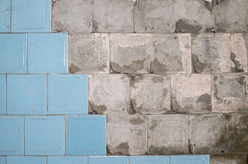 Concrete old wall with the remains of tiles and tile mortar. Background, texture.