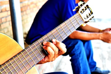 Fototapeta na wymiar Practicing in playing guitar. Handsome young men playing guitar. Close-up