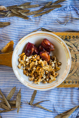 Dry fruits in bowl. Dates and walnuts. Sweet eastern traditional food and healthy superfood snack from Iran, India, Africa, South America. Raw vegan vegetarian food