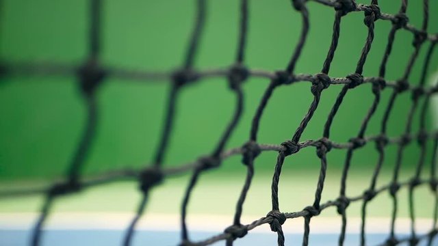 Close up of tennis equipment on the court. Sport, recreation concept. Yellow tennis balls hit the net on a clay green blue court next to the white line with copy space and soft focus