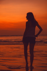 Silhouette of a girl in sunset / sunrise time over the ocean.