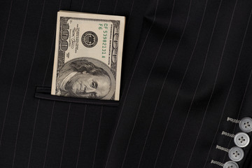 Money in a jacket..Hundred dollar banknotes stacking in the outside pocket of businessman jacket ,...