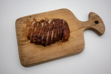 Roasted duck on wooden cutting board isolated on white