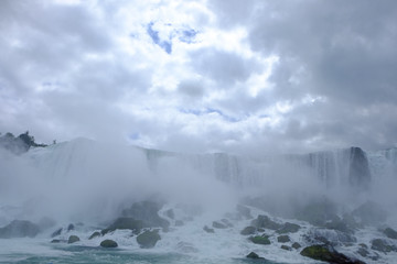 Mist and spray rising up from the rocks at the bottom of Niagara Falls to meet the clouds