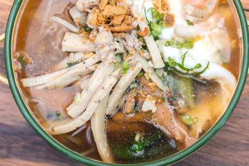 Vietnamese rice noodle soup with sliced ​​pork and chicken feet spicy soup in bowl made of coconut shell with sauce, Traditional food of Vietnamese.