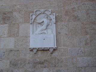 Marble plaque with a small sculptural composition on a stone wall