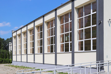 Lubno, Poland - july 9 2018: The modern sports hall of the village school. The eduction building of the younger generation. Walls with large glazed windows. Design solution for the facade of the build