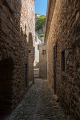 View into a narrow and dark cobbled alley in the old French village Labeaume on the river Ardeche in France
