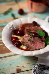 Duck breast with cherry sauce and polenta.style rustic