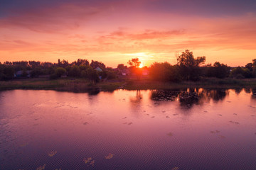 Magical purple sunrise over lake. Misty morning, rural landscape, wilderness